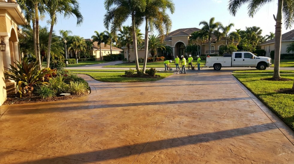 Stamped concrete driveway with crew and work truck at a Florida suburban home